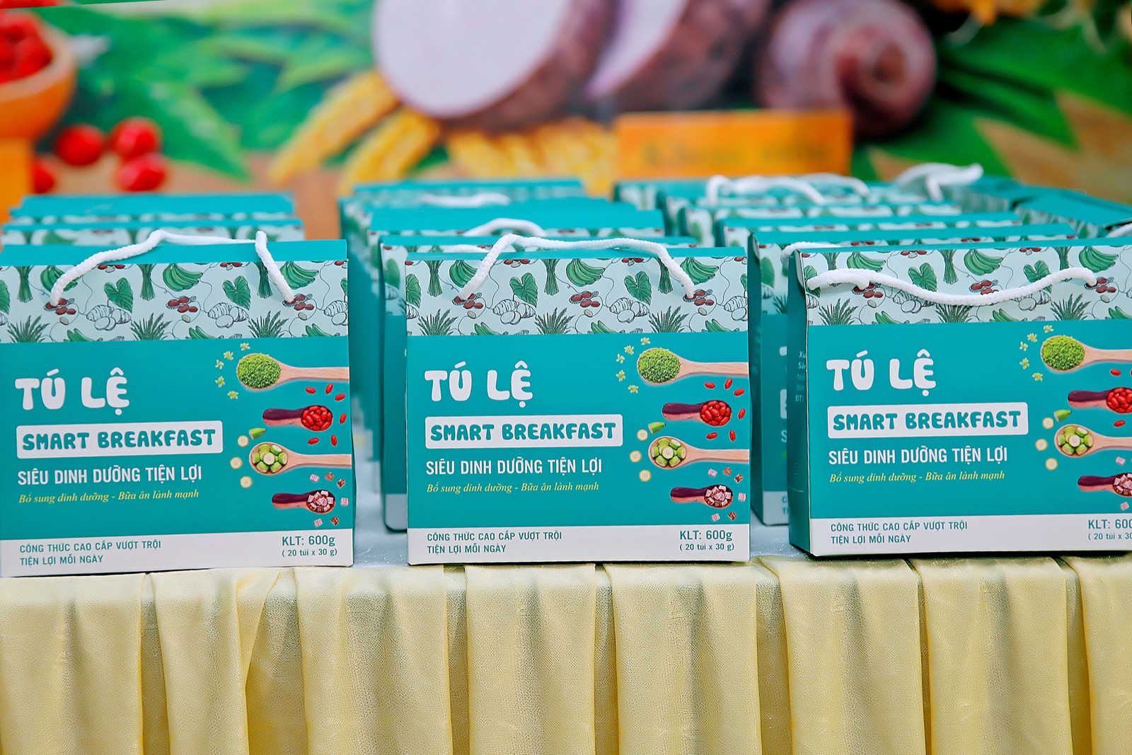 Nhiều hộp quà Tú Lệ Smart Breakfast màu xanh teal xếp trên bàn tại một buổi trưng bày sản phẩm