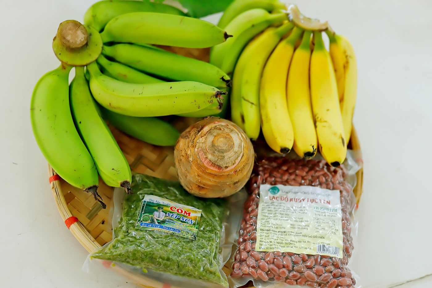 Khay tre đựng chuối xanh, chuối chín, một củ khoai môn, một túi cốm Tú Lệ và một túi lạc đỏ Lục Yên