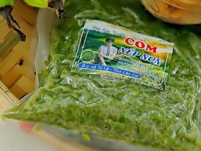 Túi cốm nếp non đặc sản Tú Lệ màu xanh, nhãn ghi xã Tú Lệ tỉnh Lào Cai, đặt trên khay tre